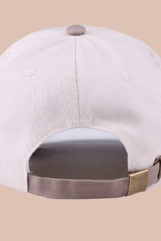 White cap with brown brim on a beige background