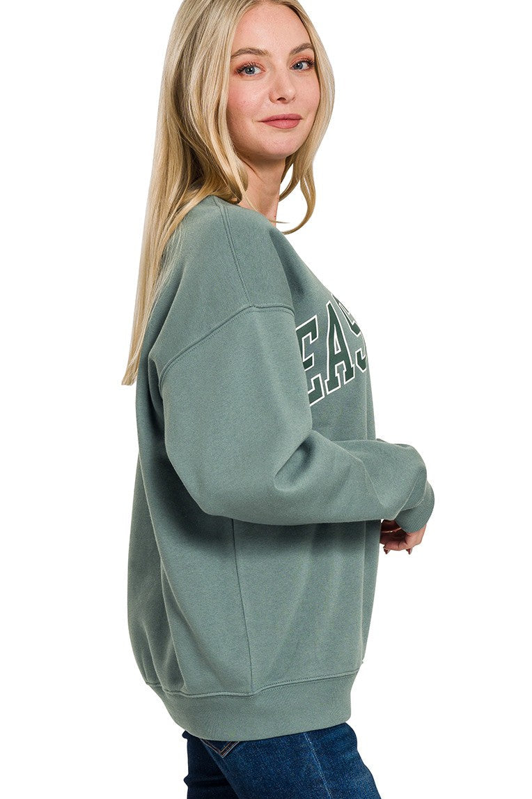 Person wearing a green sweatshirt with text on a white background
