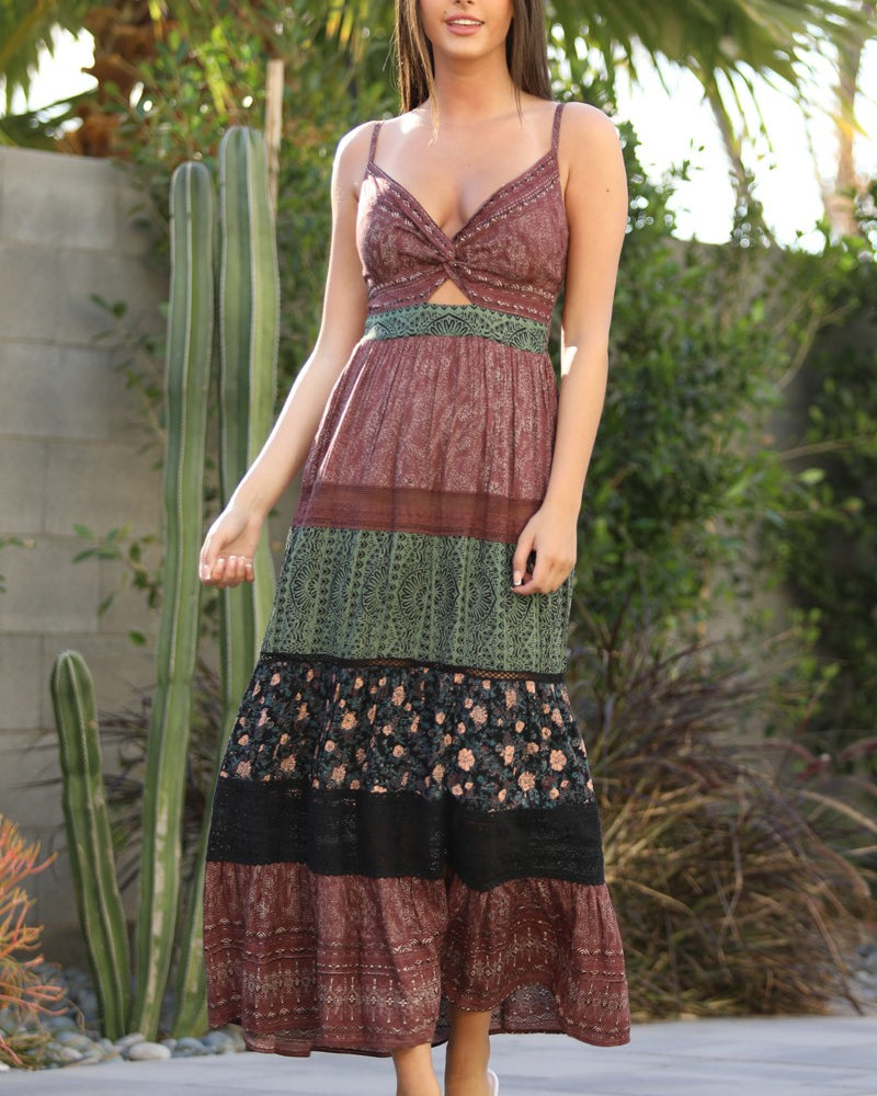 Woman wearing a colorful patchwork dress standing outdoors with cacti in the background