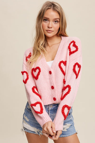 baby pink knitted cardigan with red puff hearts and red buttons