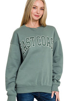 Woman wearing a green sweatshirt with 'East Coast' text on a white background